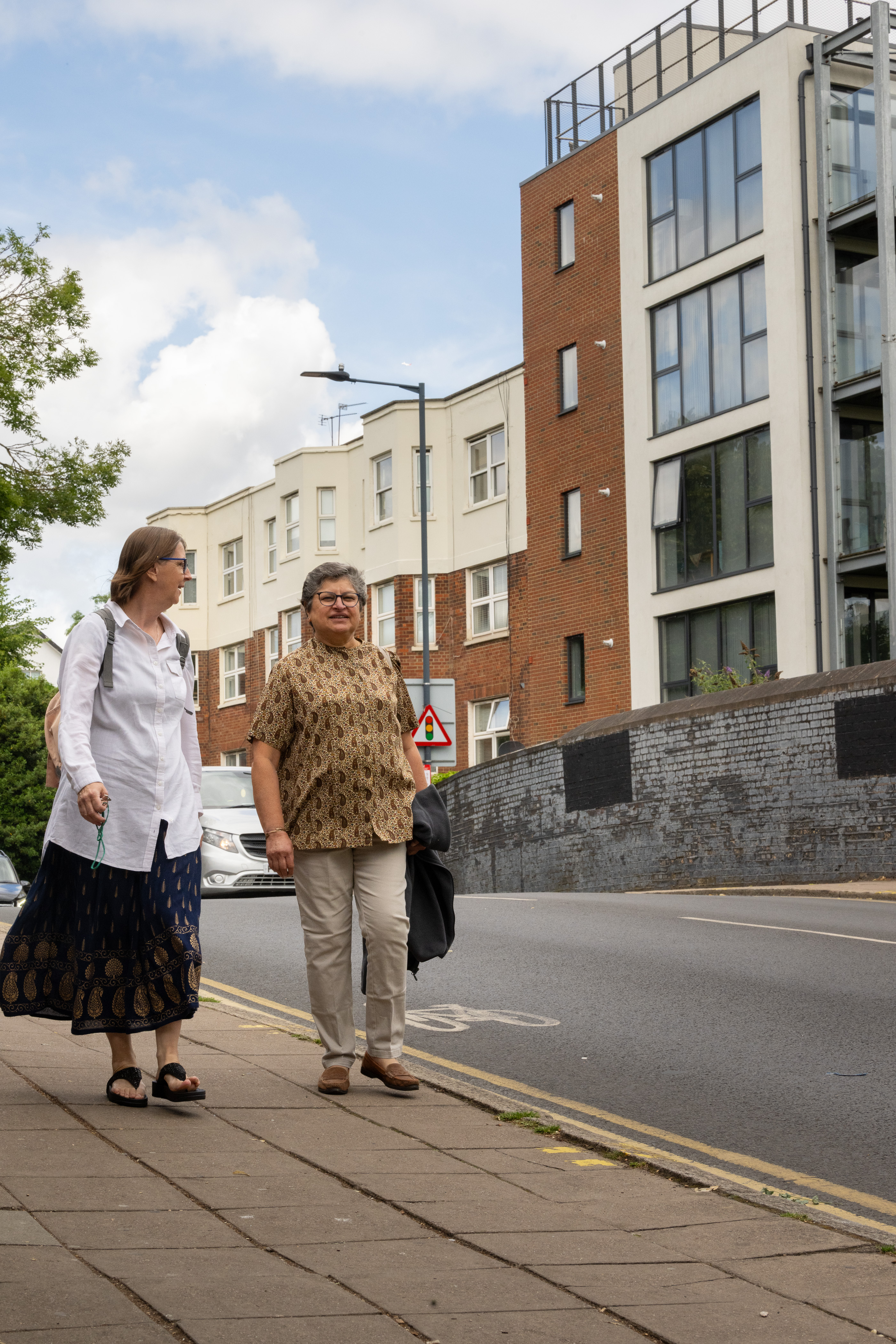 Prati and Sylvie walking past some of the new hi rise building in their area