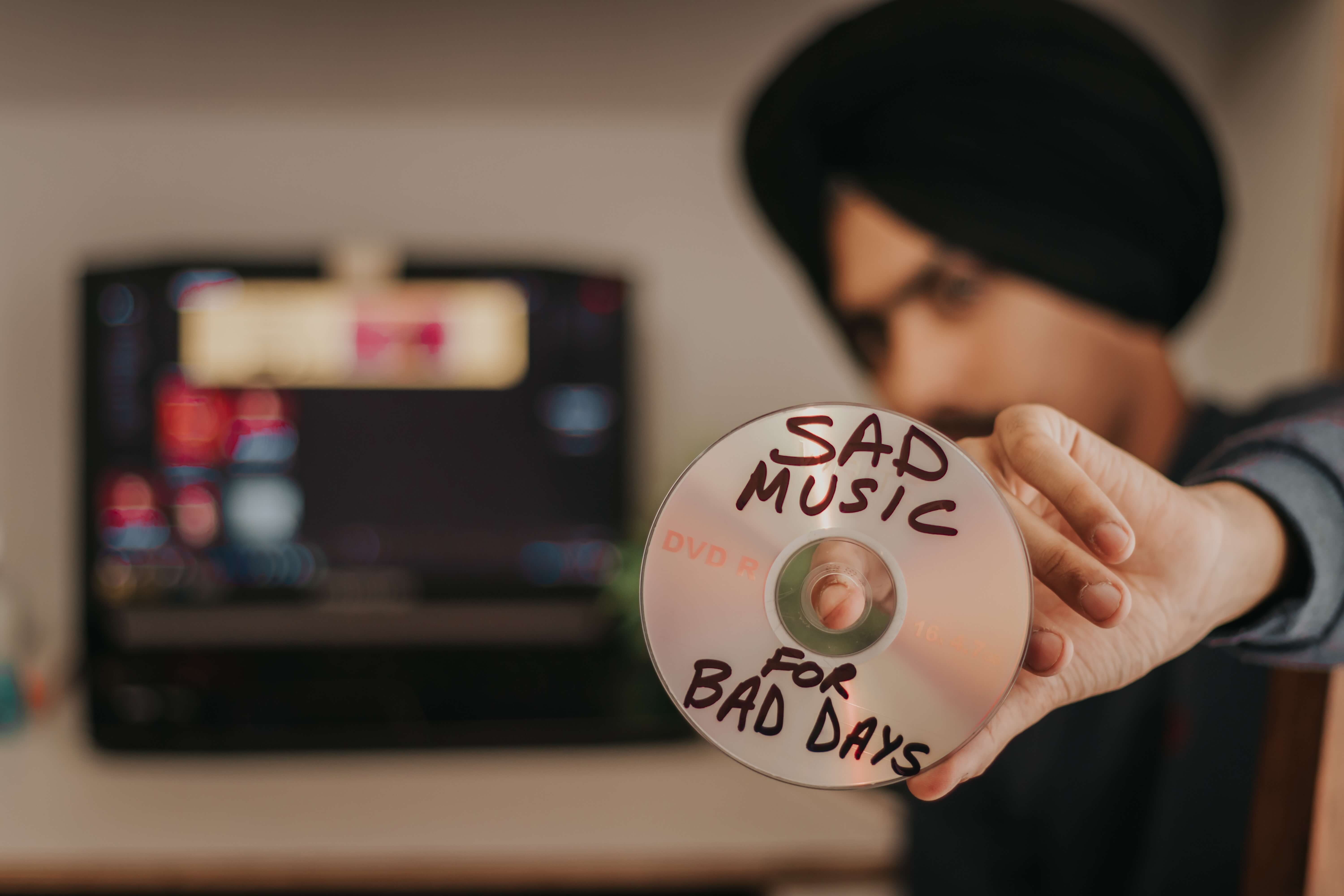 Man holding a CD which says Sad Music for Bad Days
