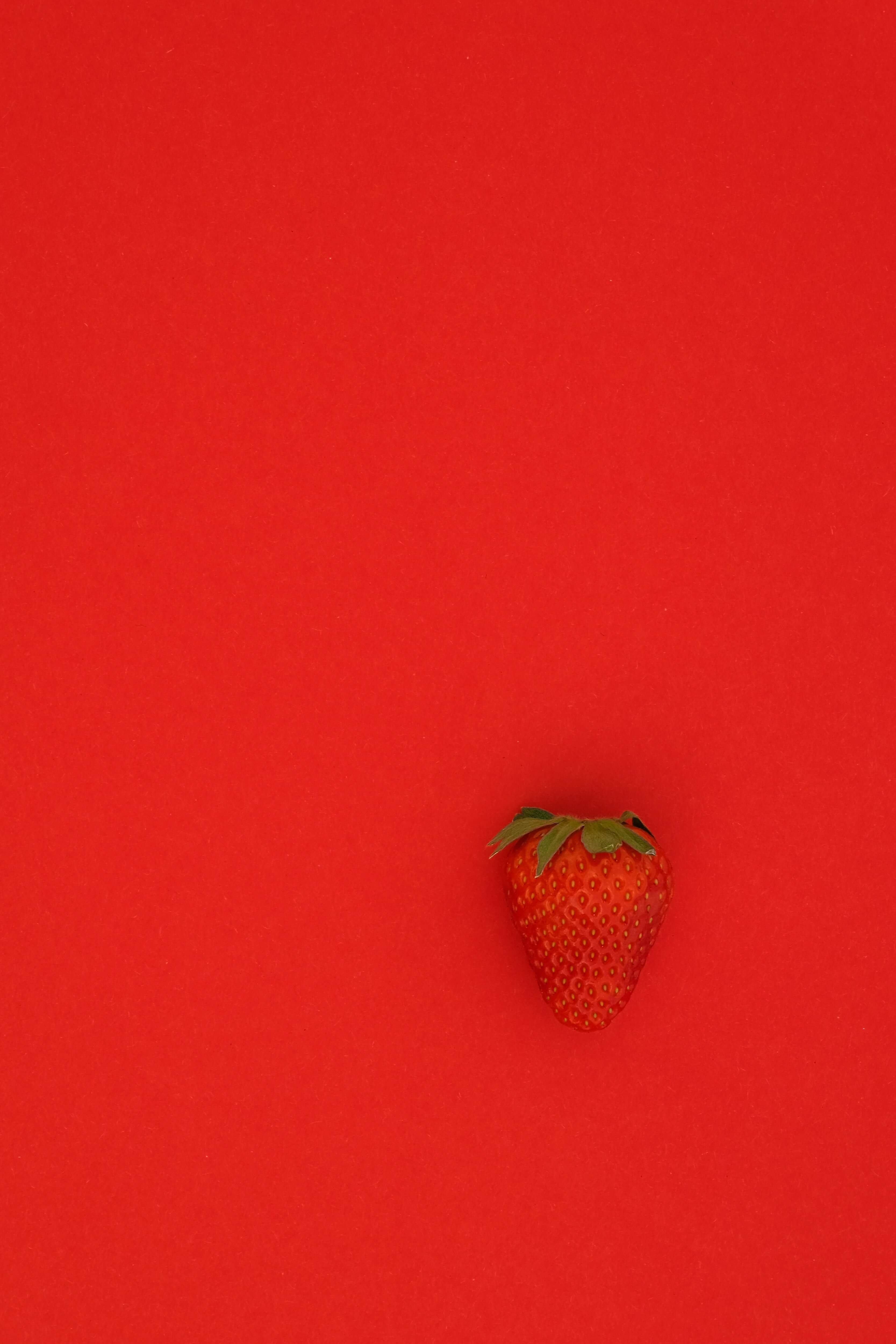 A strawberry on a red background.