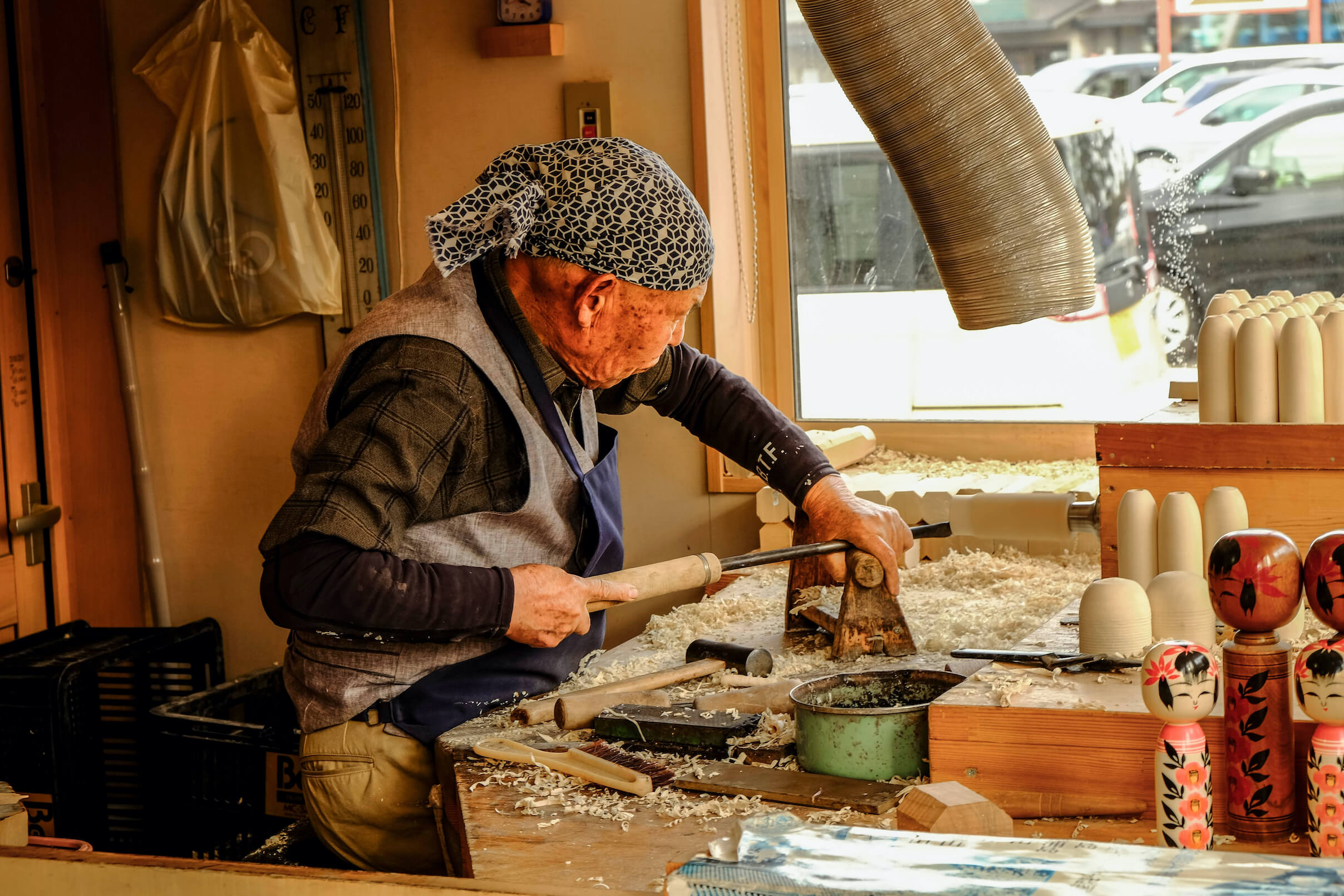 Much older Japanese man in his woodwork room
