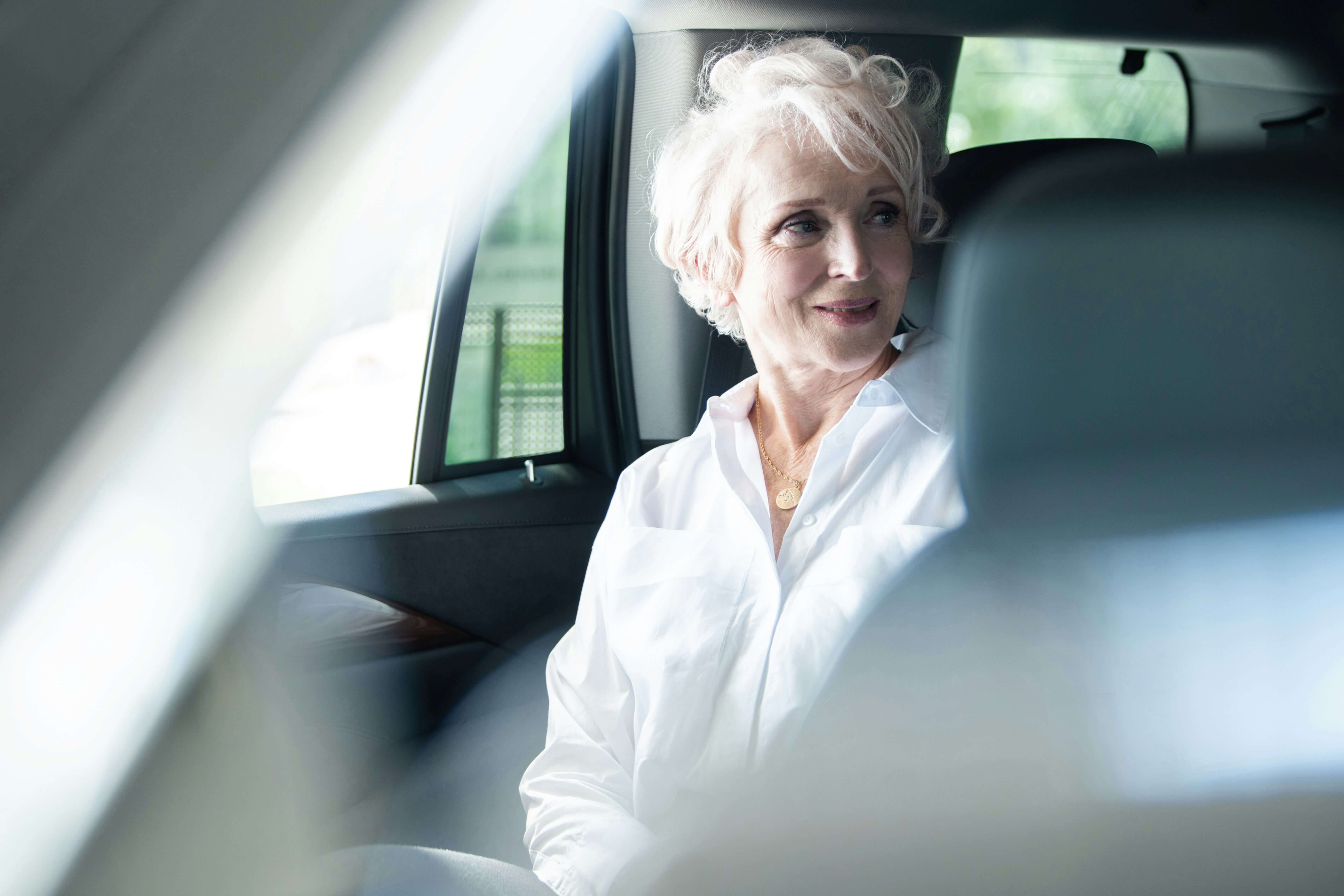 Older woman in back of a car