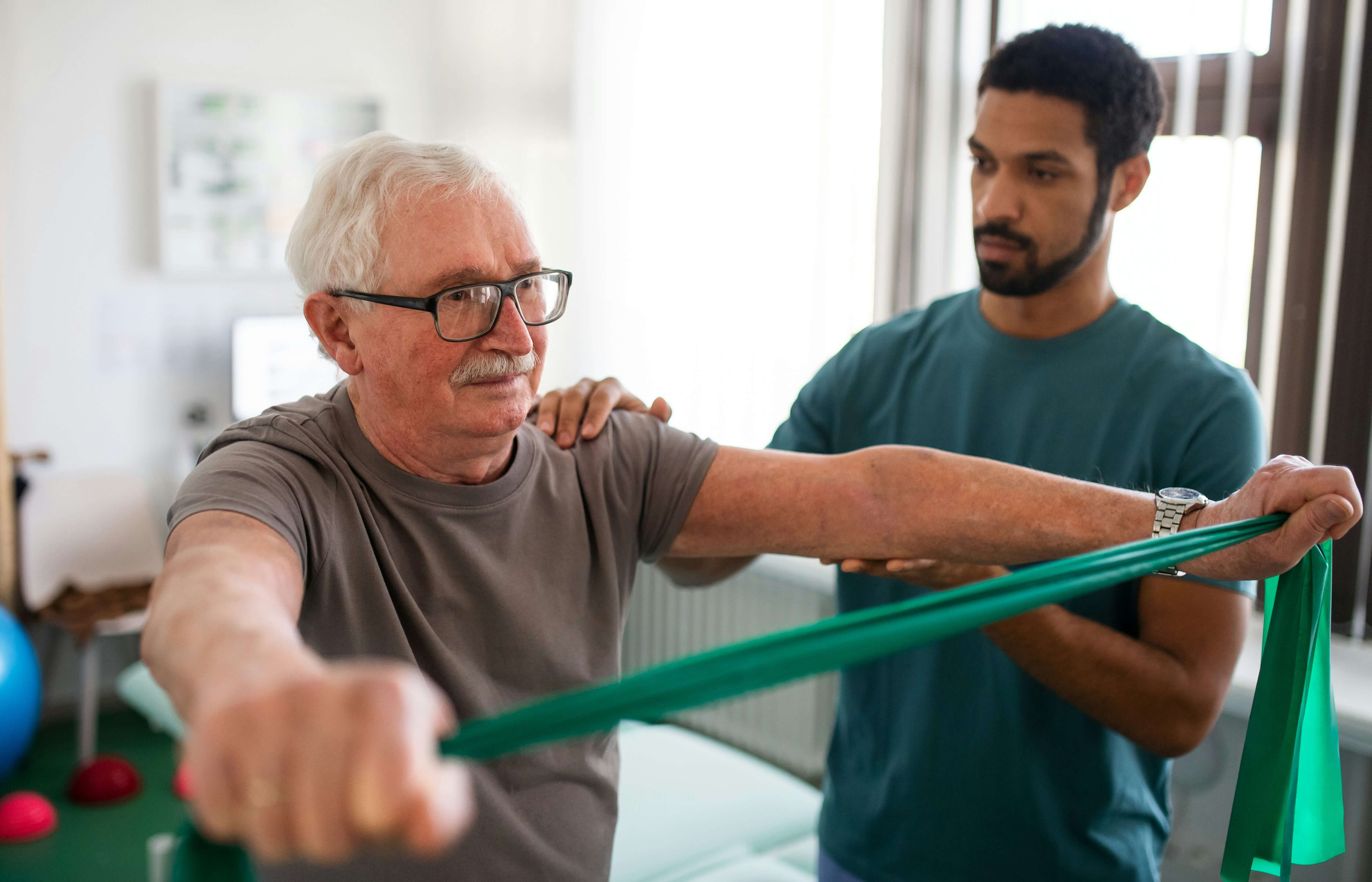 Man using strength band with trainer