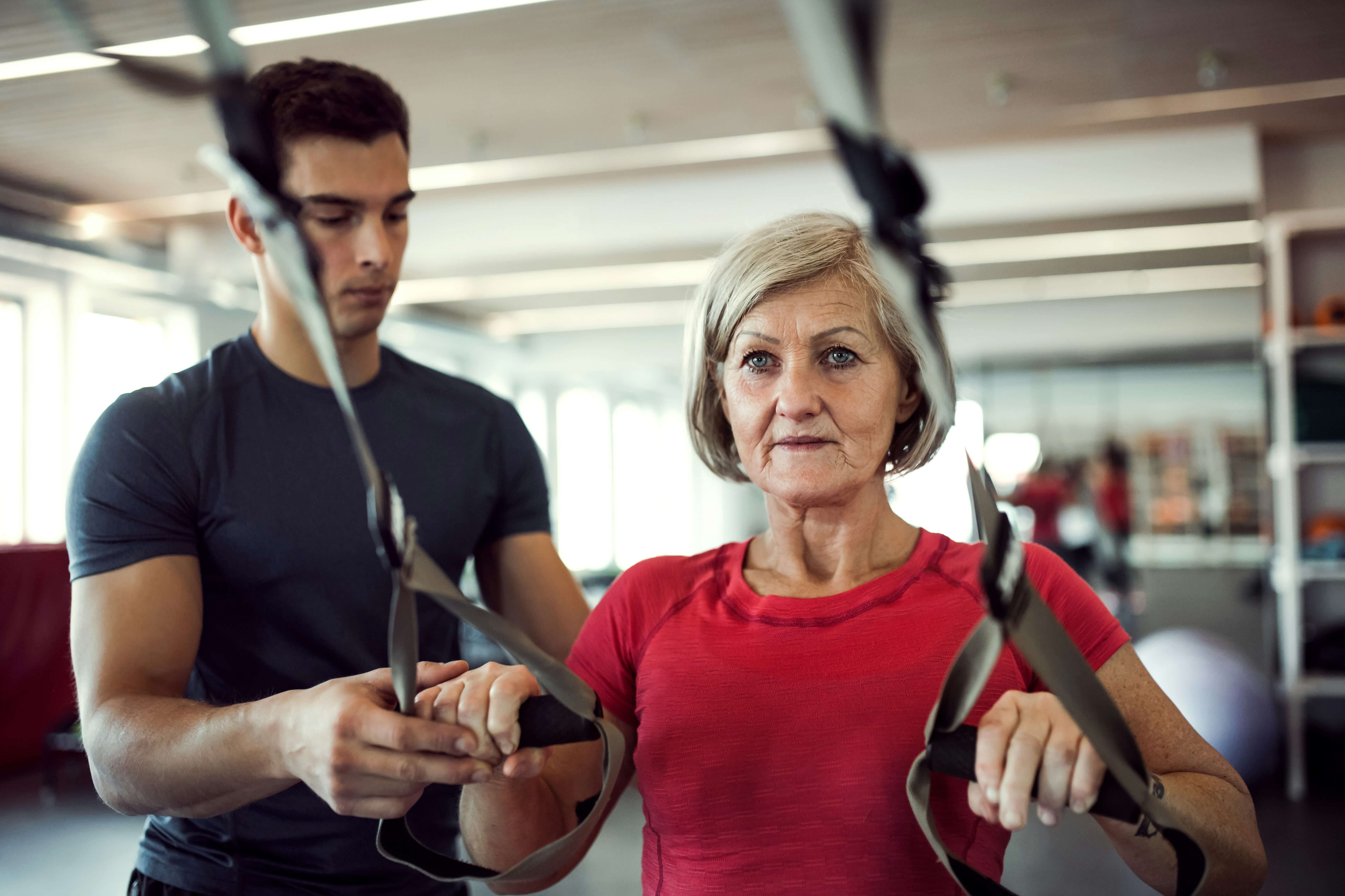 Women using weight band with trainer