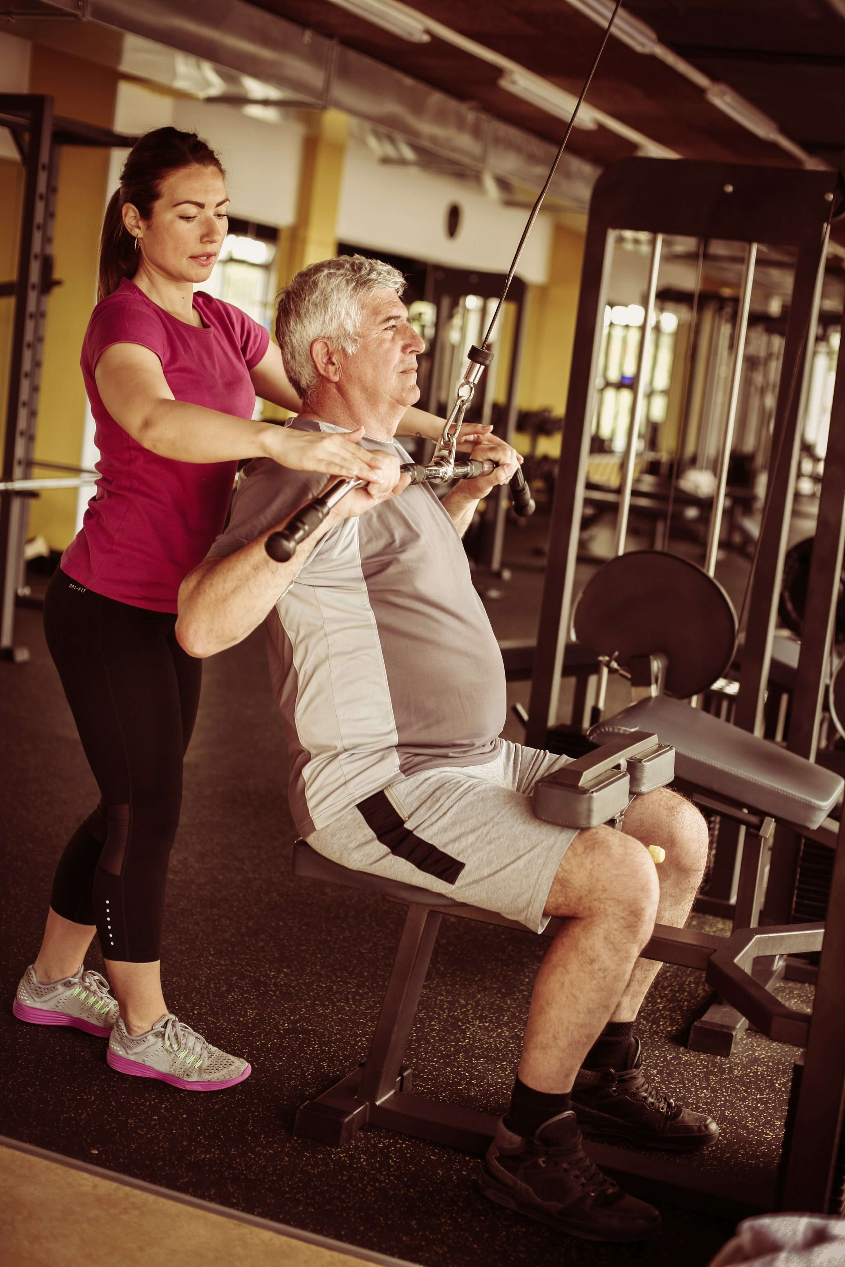 Man doing weights with trainer