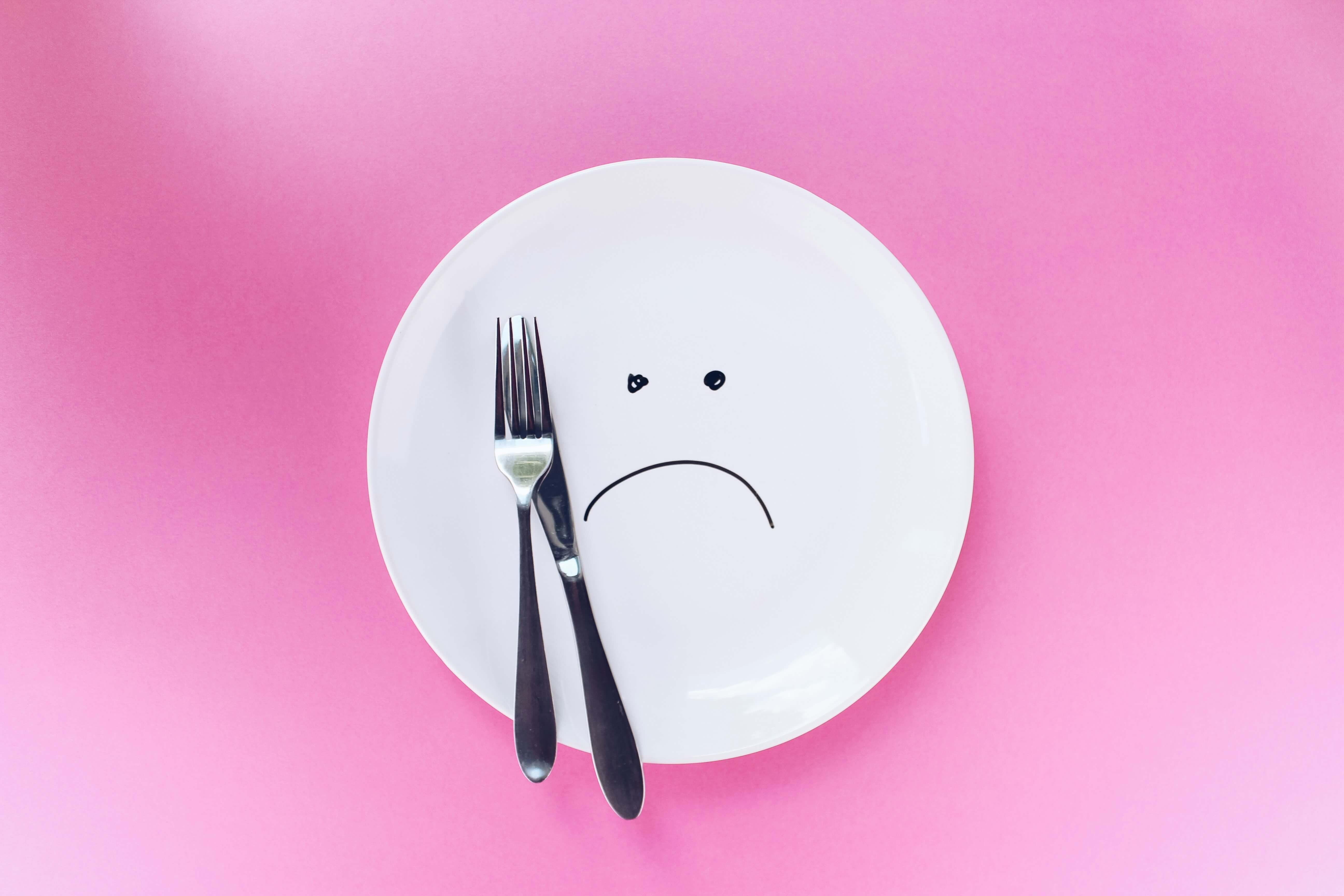 Empty plate on a pink background