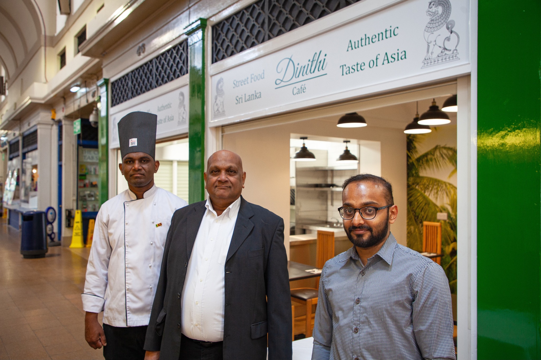 Three Grainer Market makle traders one wearing a chefs outfit outside an Indian Deli