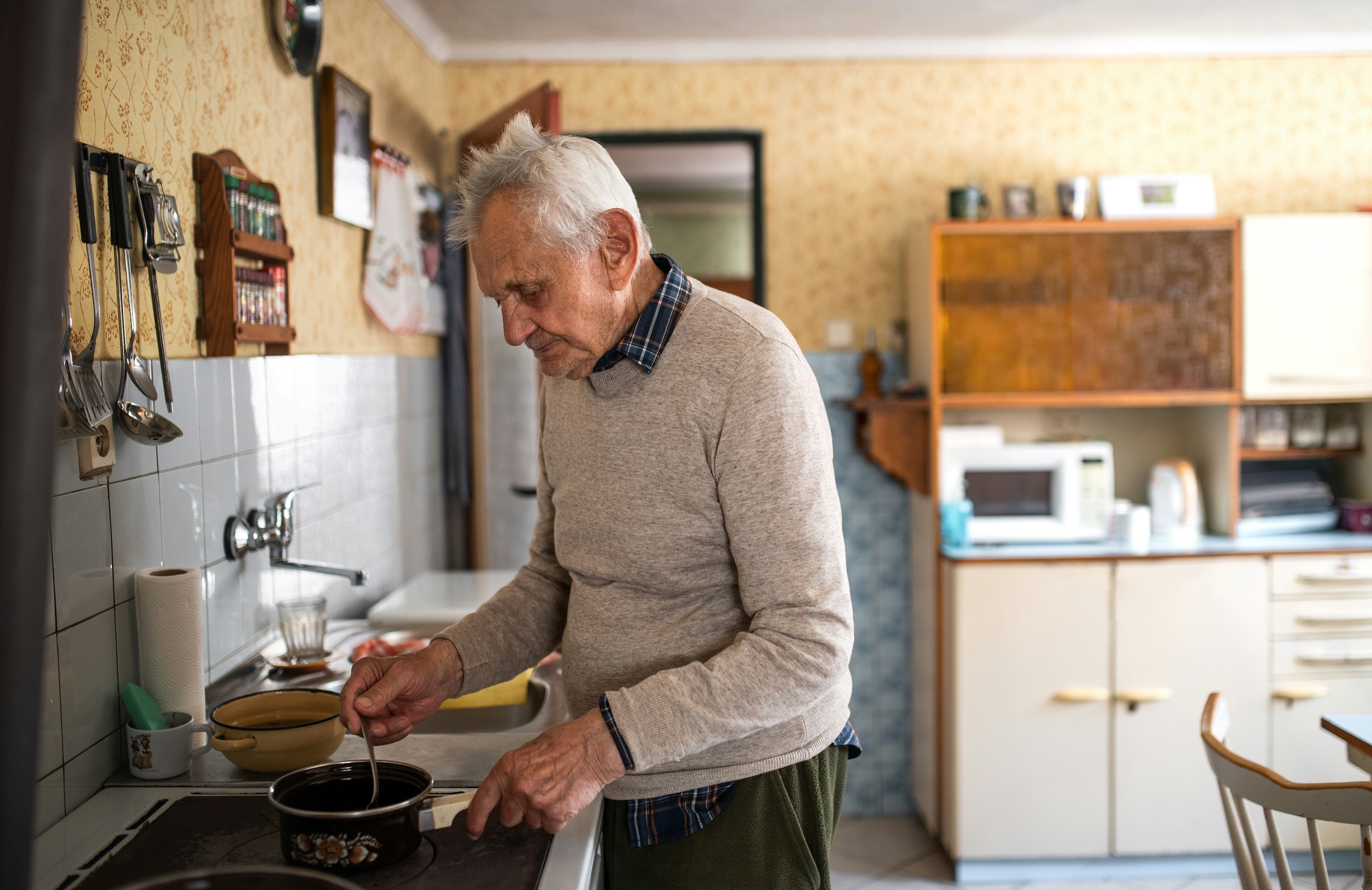 Older man in his kitchen cooking