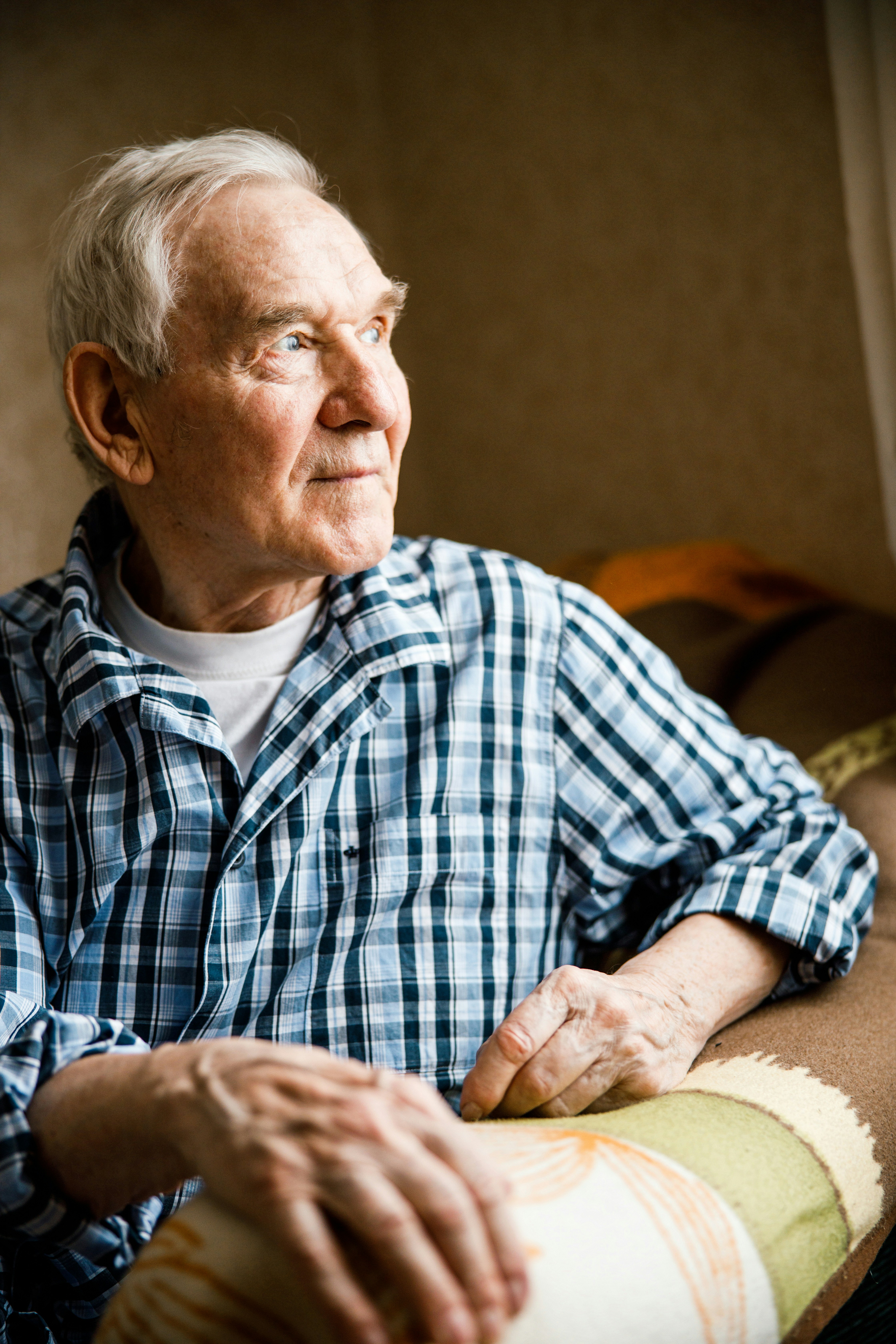 Older man sitting looking at something that you can't see