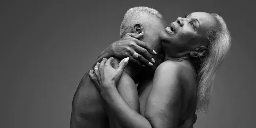 An older Black couple, nude and embracing