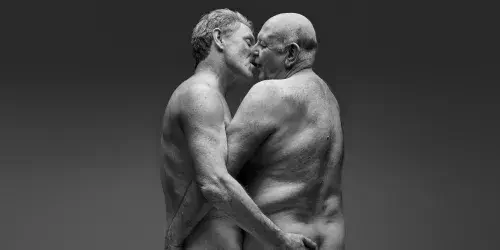 Older naked gay couple kissing