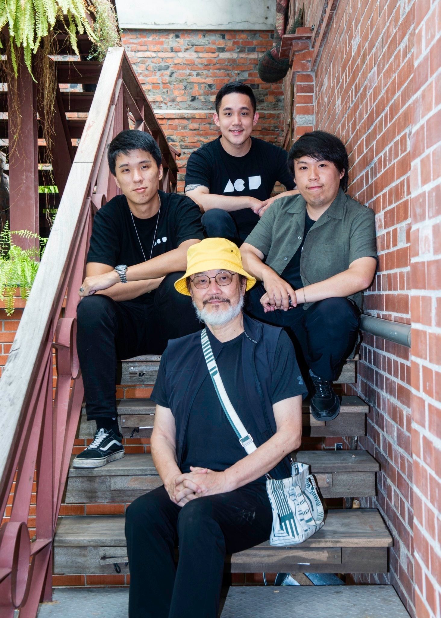 Dr. Lin sitting on some steps with three young people