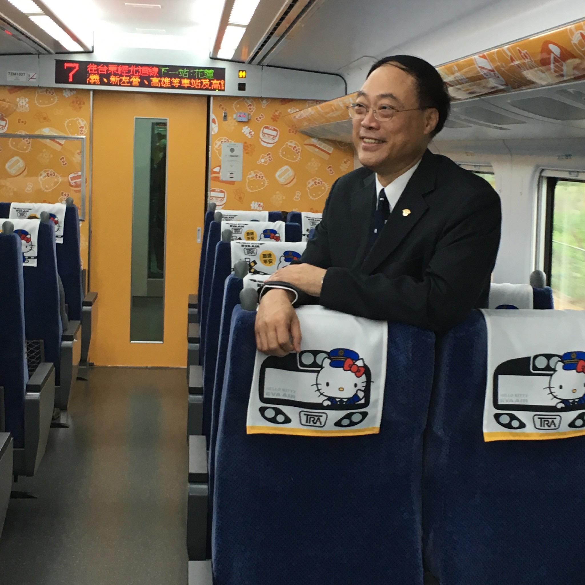 Dr. Chou smiling, standing on a train.