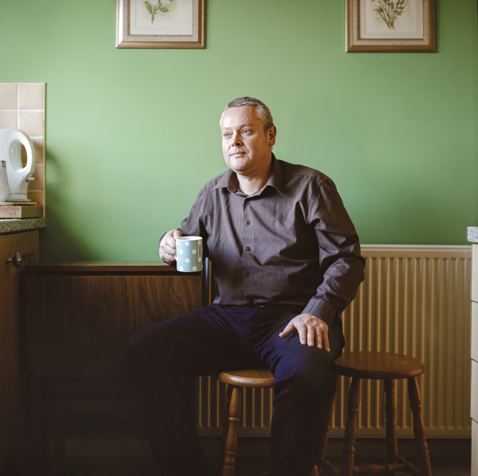 David sitting in his house drinking a cup of tea.