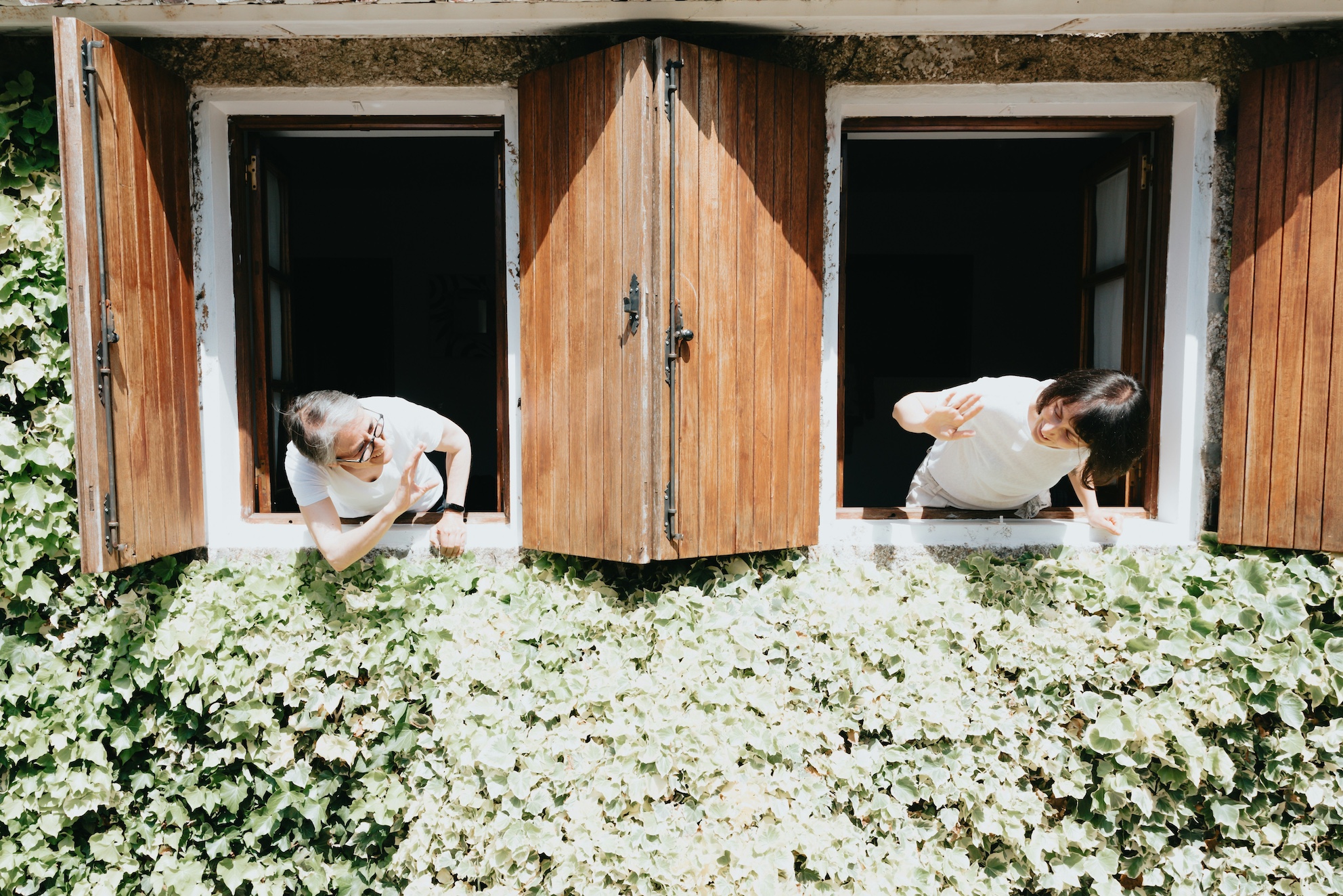 Two people looking at each from their apartment windows