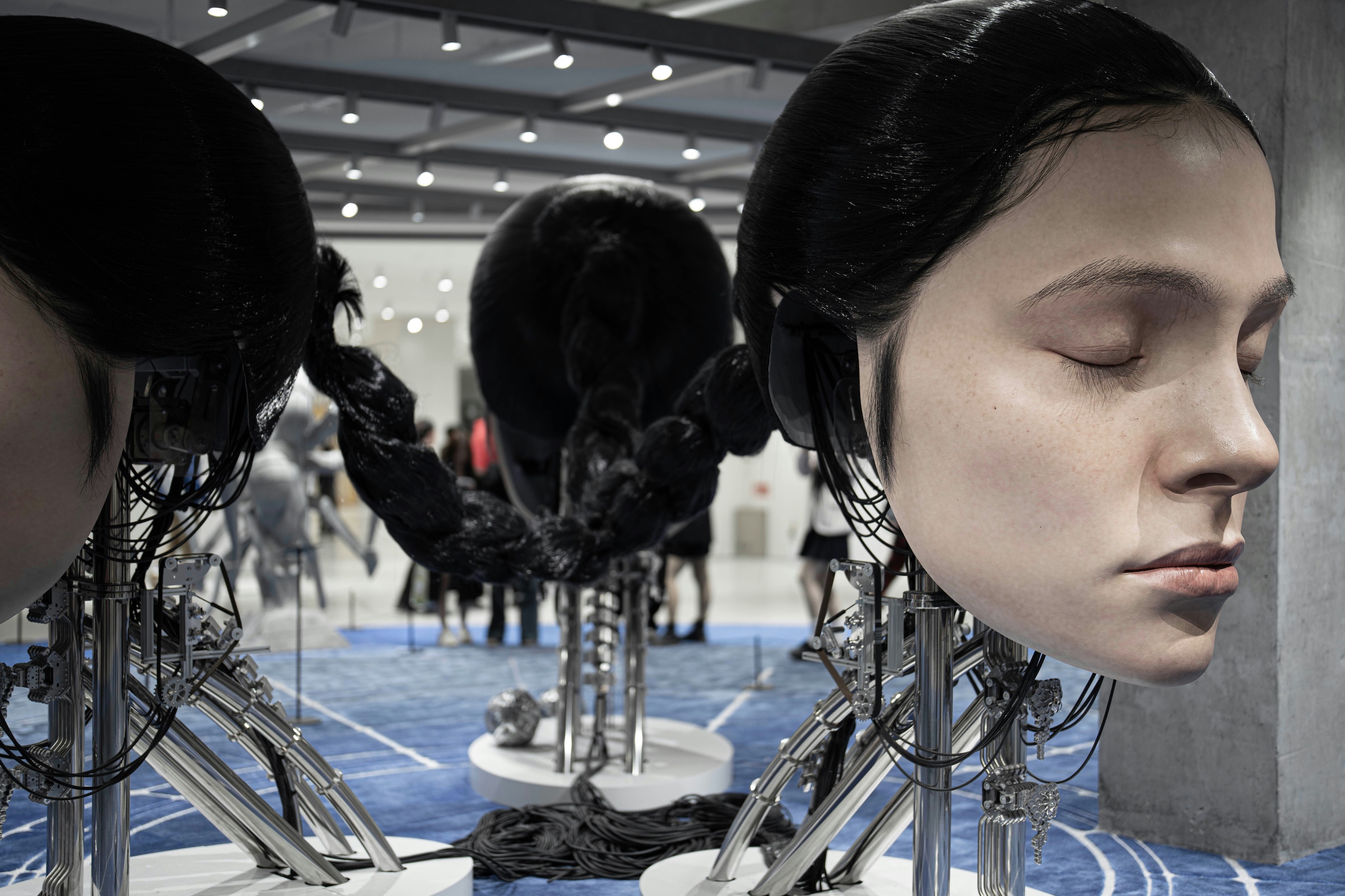 A robot head with a perfect human face of a young woman asleep