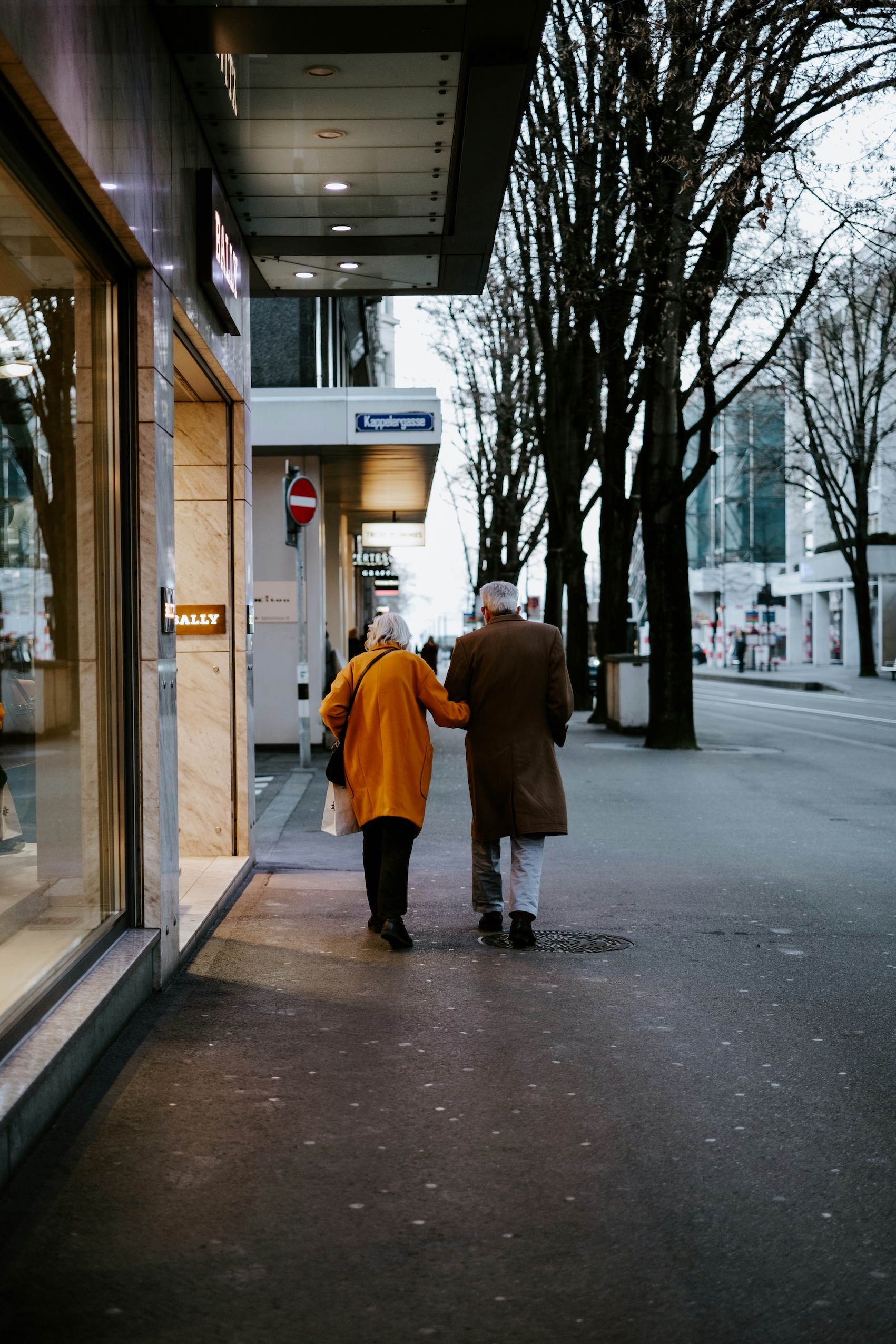An older couple walking down a quiet high street