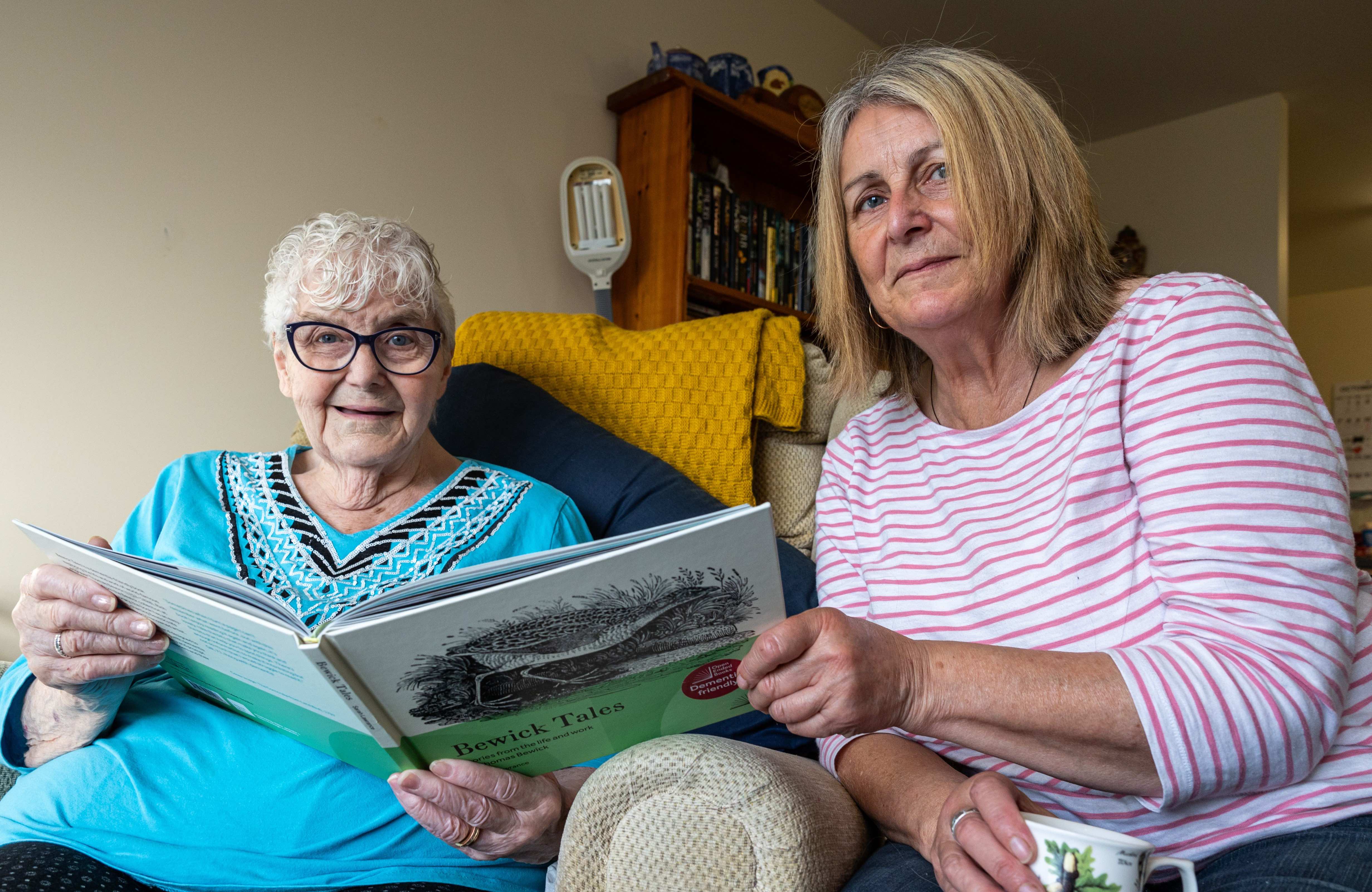 Two women reading an Open Book togther