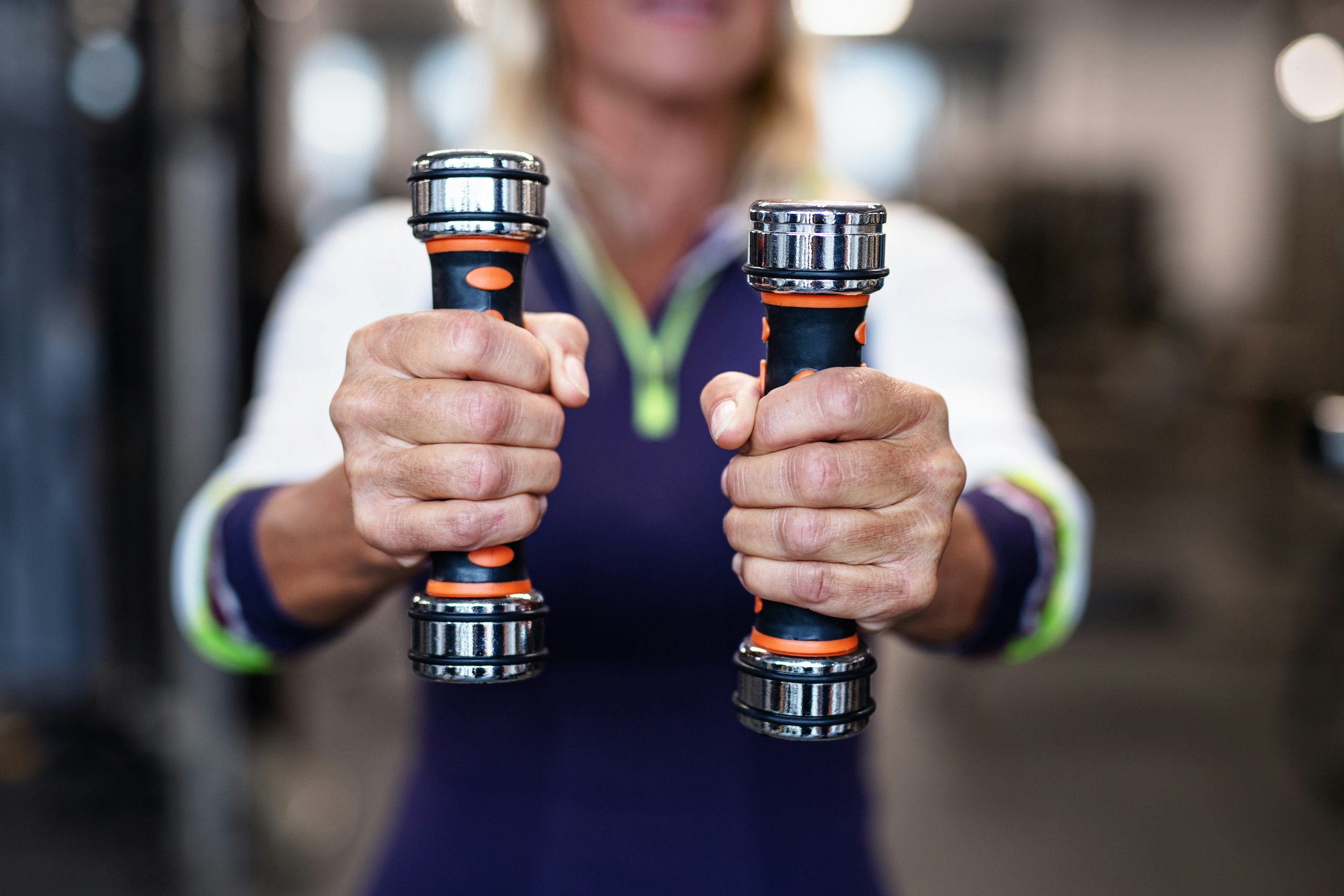 Woman holding hand weights to the camera