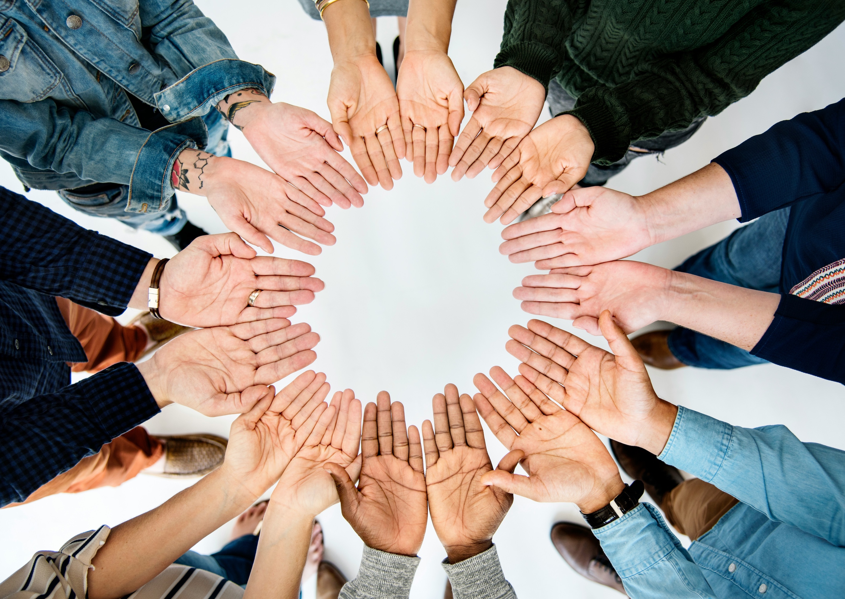A photograph of lots of hands positioned in a circle