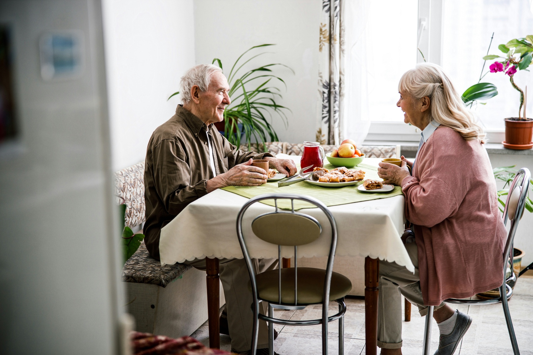 An older couple having eating a small table