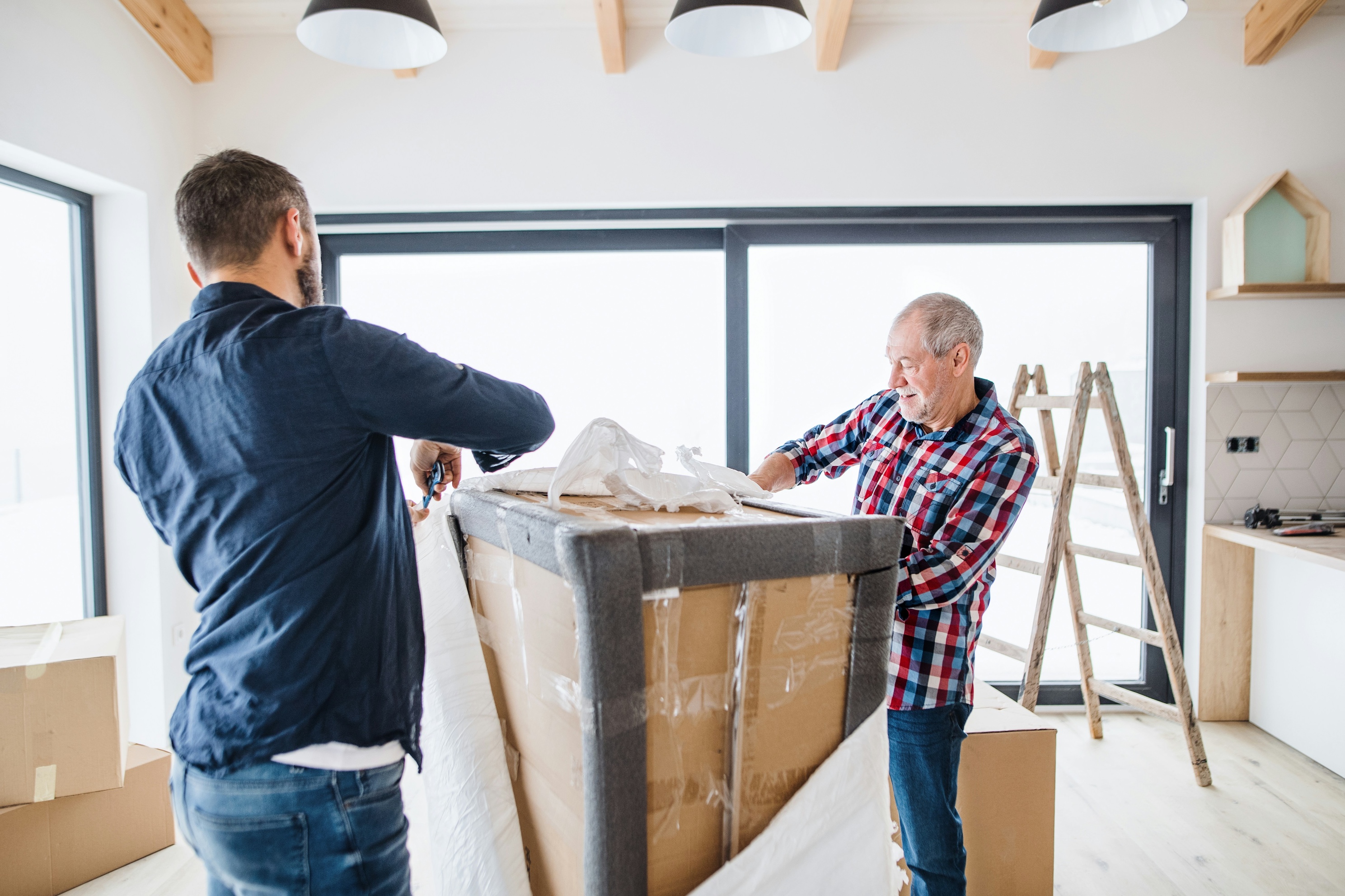 An older man and a younger man packing up their home